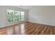 A spare bedroom featuring three large windows and hard wood floors at 8970 Ruel Ln, Suwanee, GA 30024