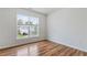Unfurnished bedroom with wood floors and a bright window showcasing the outside neighborhood at 8970 Ruel Ln, Suwanee, GA 30024