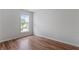 Empty bedroom with wood flooring, one window and white walls at 8970 Ruel Ln, Suwanee, GA 30024