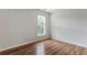 An empty bedroom featuring hard wood floors, neutral walls and a bright window at 8970 Ruel Ln, Suwanee, GA 30024