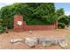 Stone community sign surrounded by mature trees, rocks, and landscaping at 8970 Ruel Ln, Suwanee, GA 30024