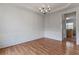 Elegant dining room featuring modern chandelier, neutral walls, and rich hardwood flooring at 8970 Ruel Ln, Suwanee, GA 30024