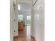 Hallway view showcasing hardwood floors leading to the kitchen and sliding glass door at 8970 Ruel Ln, Suwanee, GA 30024