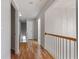 Upstairs hallway with wood flooring and white railings overlooking the staircase and lower level at 8970 Ruel Ln, Suwanee, GA 30024