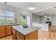 Kitchen with central island, sink with window and view to living room fireplace at 8970 Ruel Ln, Suwanee, GA 30024