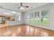 Bright living room with wood flooring, ceiling fan, and large windows overlooking the backyard at 8970 Ruel Ln, Suwanee, GA 30024