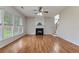 Bright living room with fireplace, wood flooring, and large windows offering natural light at 8970 Ruel Ln, Suwanee, GA 30024
