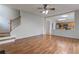 Spacious living room featuring wood flooring, a ceiling fan, and an open view to the kitchen at 8970 Ruel Ln, Suwanee, GA 30024