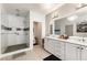 Bright bathroom showcasing a glass-enclosed shower, double vanity with modern lighting, and neutral tile flooring at 132 Grand Cres, Alpharetta, GA 30009