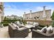 Back patio showcasing an outdoor lounge area with plush seating, manicured greenery, and privacy walls at 132 Grand Cres, Alpharetta, GA 30009