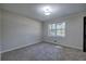 Bedroom featuring neutral walls, carpet, a light fixture, and a window with exterior views at 380 Inman Rd, Fayetteville, GA 30215