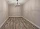 Versatile empty room with hardwood floors and a modern chandelier at 380 Inman Rd, Fayetteville, GA 30215
