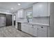 Kitchen featuring white cabinets, stainless steel appliances, and gray wood flooring at 380 Inman Rd, Fayetteville, GA 30215