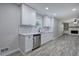 Bright kitchen featuring white cabinets, stainless steel appliances, and gray wood flooring at 380 Inman Rd, Fayetteville, GA 30215