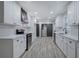 Modern kitchen with stainless steel appliances, white cabinets, and gray wood flooring at 380 Inman Rd, Fayetteville, GA 30215