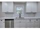 Close up kitchen view of white cabinets, stainless steel appliances and gray wood flooring at 380 Inman Rd, Fayetteville, GA 30215