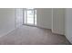 Carpeted room featuring a window, door, and neutral colors. Awaiting a personalized touch at 405 Rosedown Way, Lawrenceville, GA 30043