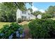 Landscaped front yard showcasing a two-story home with a blue front door and mature plantings at 405 Rosedown Way, Lawrenceville, GA 30043