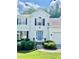 Traditional home featuring manicured shrubbery, a blue front door, and an attached two car garage at 405 Rosedown Way, Lawrenceville, GA 30043