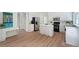 Open-concept kitchen with white cabinets, stainless appliances, hardwood floors, and a cozy breakfast bar at 405 Rosedown Way, Lawrenceville, GA 30043