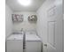 Bright laundry room with modern, white washer and dryer, plus shelving for organization at 405 Rosedown Way, Lawrenceville, GA 30043