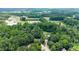 Expansive aerial view showcases this private estate nestled amongst mature hardwoods with a long drive and circular front at 5885 Millstone Dr, Cumming, GA 30028