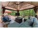 Outdoor living space with TV, cozy seating around a fire pit, and umbrella-shaded dining area at 5885 Millstone Dr, Cumming, GA 30028
