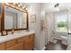Well-lit bathroom featuring wood-trimmed mirror, wooden cabinets, and a shower-tub combo at 5885 Millstone Dr, Cumming, GA 30028