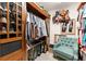 Organized walk-in closet with wooden storage, clothing racks, and a cozy chair in the corner at 5885 Millstone Dr, Cumming, GA 30028