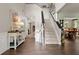 Inviting foyer with hardwood floors, staircase, and stylish console table, creating an open, airy feel at 5885 Millstone Dr, Cumming, GA 30028