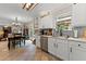Open-concept kitchen with stainless steel appliances, tile flooring, and seamless flow to dining and living areas at 5885 Millstone Dr, Cumming, GA 30028