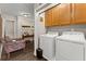 Convenient laundry room featuring modern appliances and overhead storage for efficient organization at 5885 Millstone Dr, Cumming, GA 30028