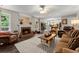 Cozy living room with a brick fireplace, ceiling fan, and hardwood floors extending into the dining area at 5885 Millstone Dr, Cumming, GA 30028