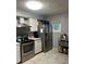 Kitchen featuring stainless steel appliances, tile floors, and abundant cabinet space at 6658 Ramsgate Way, Norcross, GA 30093