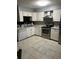 White kitchen featuring stainless steel appliances, and tile floors at 6658 Ramsgate Way, Norcross, GA 30093
