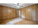 A bedroom with wood-paneled walls, hardwood floors, ceiling fan, and doorways to other rooms at 109 Amberidge Nw Dr, Cartersville, GA 30121