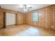 Generously sized bedroom with wood-paneled walls, a ceiling fan, and a large window at 109 Amberidge Nw Dr, Cartersville, GA 30121