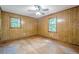 Bedroom with hardwood floors, wood paneled walls, ceiling fan, and two windows at 109 Amberidge Nw Dr, Cartersville, GA 30121