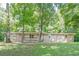 Single-story stone home with a covered front porch, nestled among tall trees and a grassy lawn at 109 Amberidge Nw Dr, Cartersville, GA 30121