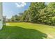 Spacious backyard features lush green grass, mature trees, and a privacy fence, perfect for outdoor activities at 2479 Mitford Ct, Dacula, GA 30019