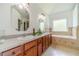 Bathroom features double sinks, granite countertops, tile backsplash, and a tiled bath/shower at 2479 Mitford Ct, Dacula, GA 30019