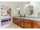 A bathroom featuring double sinks, granite countertops, with an open view to the main bedroom at 2479 Mitford Ct, Dacula, GA 30019