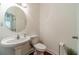 Clean, classic half-bathroom with a pedestal sink, round mirror, and hardwood floors at 2479 Mitford Ct, Dacula, GA 30019