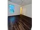 Empty bedroom with dark hardwood flooring and a window letting in natural light at 2479 Mitford Ct, Dacula, GA 30019