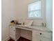 Cozy desk nook with built-in cabinets, ample storage, and a granite countertop under a bright window at 2479 Mitford Ct, Dacula, GA 30019