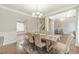 Inviting dining area with wainscotting, neutral tones, and a clear view of the staircase and living room at 2479 Mitford Ct, Dacula, GA 30019