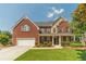 Two-story red brick home featuring a well-manicured lawn and beautiful landscaping at 2479 Mitford Ct, Dacula, GA 30019