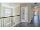 Upstairs hallway with open door and view of staircase at 2479 Mitford Ct, Dacula, GA 30019