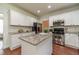 Well-lit kitchen with white cabinets, granite countertops, stainless steel appliances, and a functional island at 2479 Mitford Ct, Dacula, GA 30019