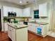 Well-lit kitchen boasting granite countertops, a central island, and white cabinets for a classic appeal at 2479 Mitford Ct, Dacula, GA 30019